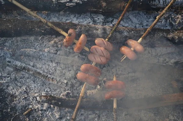 Kiełbasa na szpikulec pieczenia na ogień. — Zdjęcie stockowe