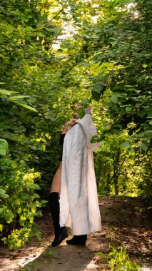 Beyaz pelerinli seksi sarışın kadın doğada