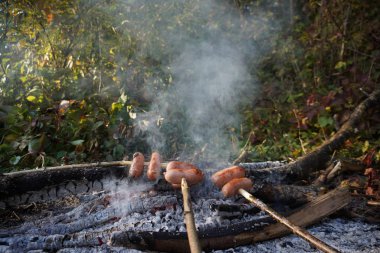 sosis ateşe kavurma bir şiş üzerinde.