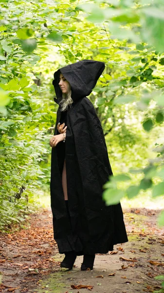 Sexy blonde woman in black cloak nature — Stock Photo, Image