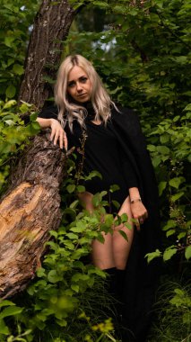 Siyah pelerinli seksi sarışın kadın.