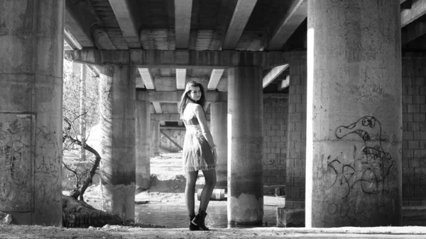 Νεαρή Κοπέλα Μαύρο Φόρεμα Που Ποζάρει Κάτω Από Γέφυρα — Φωτογραφία Αρχείου