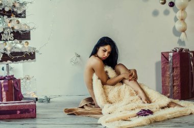 Yeni yıl dekorasyonunun arka planında güzel bir esmer. Moda Güzellik Portresi. Seksi Kız.