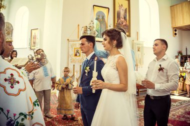 Düğün töreni. Bir buket çiçekli beyaz takım elbiseli mutlu bir çift.