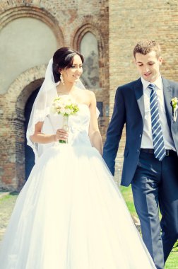 Eski kale binasının orada, parlak güneş ışığında yeni evliler.