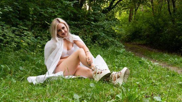 Mooie sexy blonde vrouw, het beeld van een non in een witte regenjas — Stockfoto