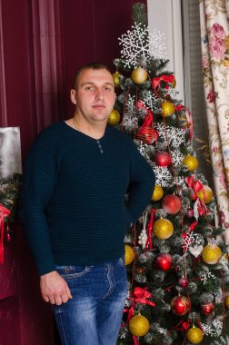 Noel ağacı olan genç bir adamın portresi. 