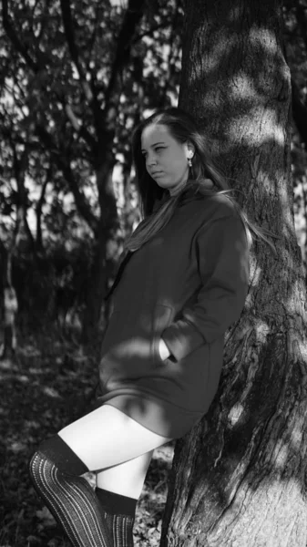 Black and white photography of beautiful amazed young woman, background outdoors