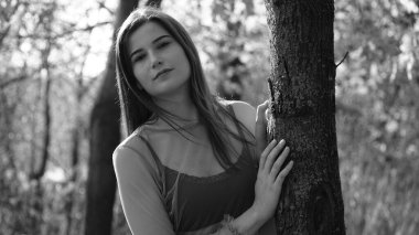 Sonbaharda parkta yürüyen genç ve güzel bir kadın.