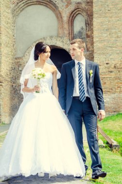 Eski kale binasının orada, parlak güneş ışığında yeni evliler.