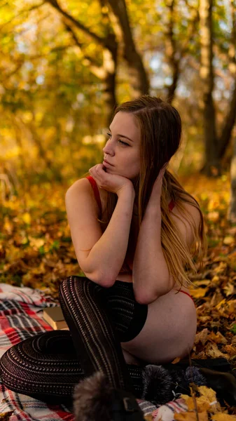 Prachtig rood haar meisje in rood pak en jas. Jonge vrouw loopt in het park — Stockfoto