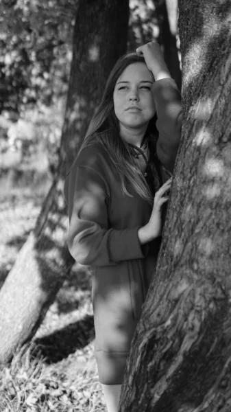 Fotografía en blanco y negro de una hermosa mujer joven sorprendida, fondo al aire libre — Foto de Stock