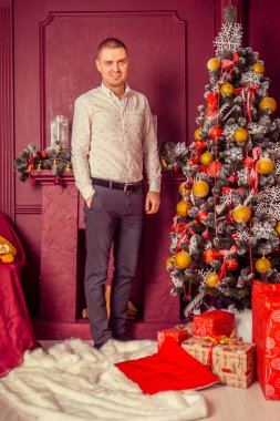 Noel süslemelerinde mutlu bir gencin portresi. 