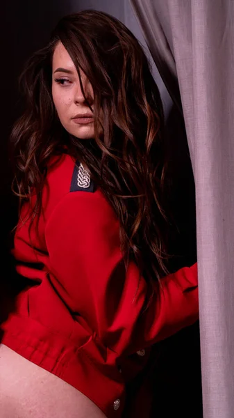 Menina em uma jaqueta vermelha em um fundo claro — Fotografia de Stock