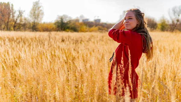 Otrolig fantastisk flicka i en röd klänning. Bakgrunden är fantastisk höst. Konstnärlig fotografi. — Stockfoto