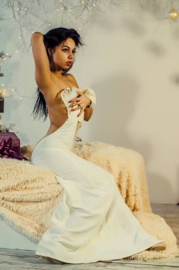 Yeni yıl dekorasyonunun arka planında güzel bir esmer. Moda Güzellik Portresi. Seksi Kız..