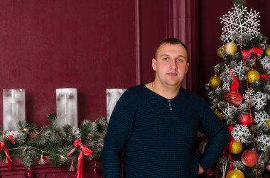 Noel ağacı olan genç bir adamın portresi. 