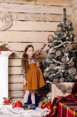 Noel süslemeli stüdyoda poz veren güzel küçük kız. 