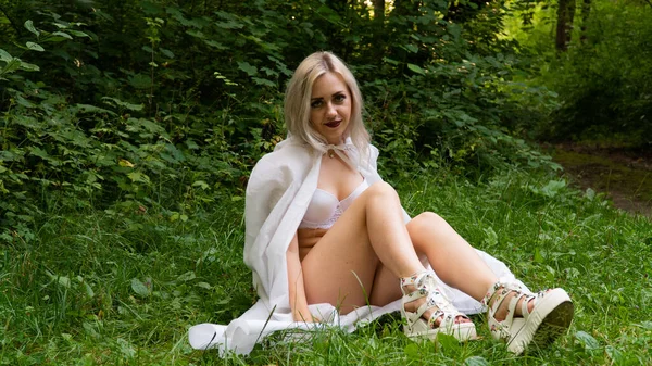 Hermosa mujer rubia sexy, la imagen de una monja en un impermeable blanco — Foto de Stock