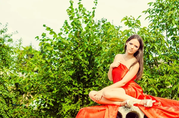 Piękna Młoda Dziewczyna Ubrana Czerwoną Sukienkę Betonowe Płyty Pozowanie Parku — Zdjęcie stockowe