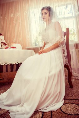 Lüks odada gelinliği olan genç ve güzel bir gelin.