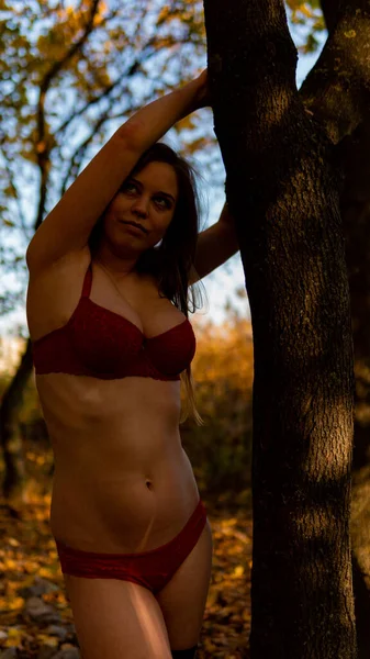 Menina de cabelo vermelho lindo em bodysuit vermelho e casaco. Jovem caminhando no parque — Fotografia de Stock