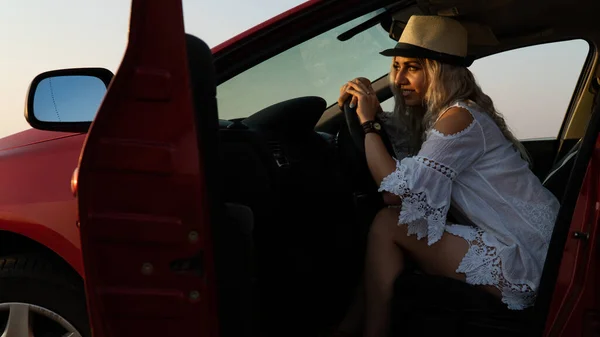 Schöne sexy blonde Frau, rotes Auto, Feld — Stockfoto
