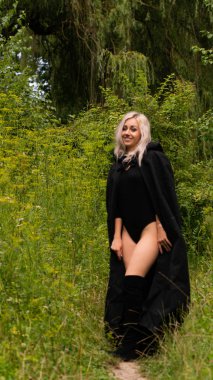 Siyah pelerinli seksi sarışın kadın.