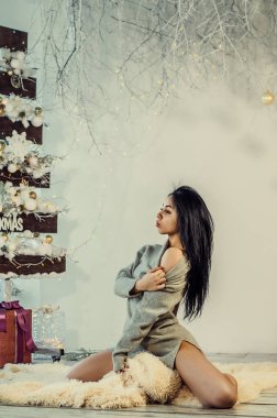 Yeni yıl dekorasyonunun arka planında güzel bir esmer. Moda Güzellik Portresi. Seksi Kız.