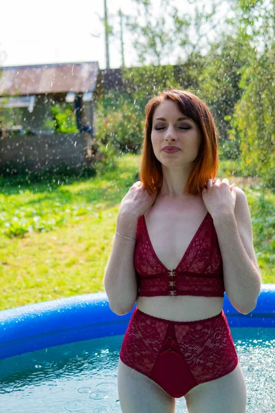 Mulher nua, cabelo vermelho molhado, natureza, piscina — Fotografia de Stock