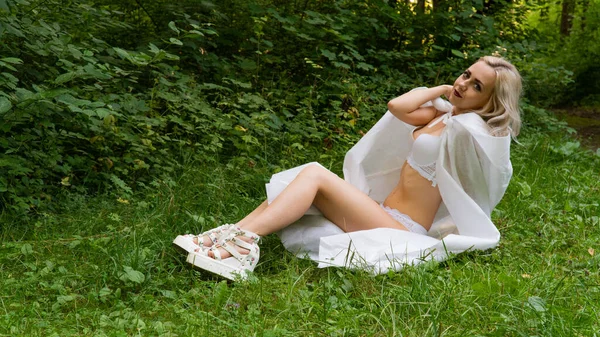 Hermosa mujer rubia sexy, la imagen de una monja en un impermeable blanco —  Fotos de Stock