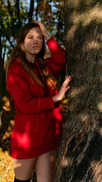 Ongelooflijk prachtig meisje in een rode jurk. De achtergrond is fantastisch herfst. Artistieke fotografie. — Stockfoto