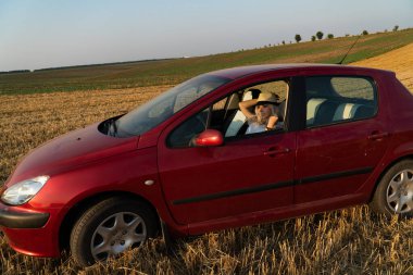 Güzel seksi sarışın kadın, kırmızı araba, tarla