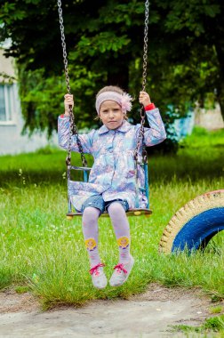 Güneşli yaz parkında oynayan 5 yaşında tatlı bir kız çocuğu. Ormanda yürüyen ve atlayan mutlu bir kız çocuğu. Çocuklar açık havada oynuyorlar..