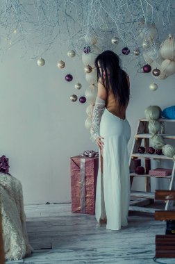 Yeni yıl dekorasyonunun arka planında güzel bir esmer. Moda Güzellik Portresi. Seksi Kız.