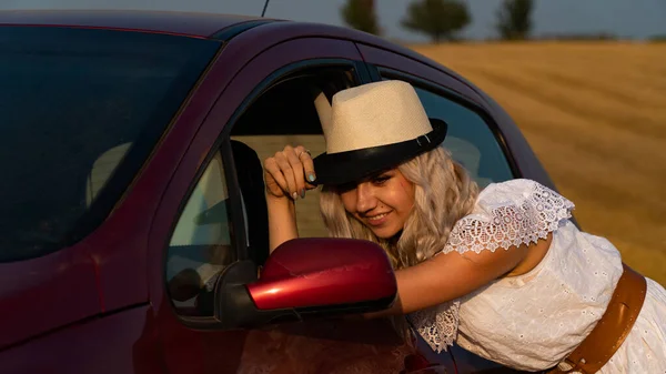 Beautiful sexy blonde woman, red car, field — Stock Photo, Image