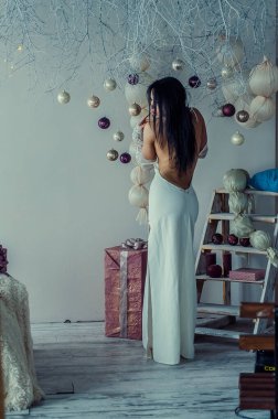 Yeni yıl dekorasyonunun arka planında güzel bir esmer. Moda Güzellik Portresi. Seksi Kız.