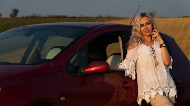 Güzel seksi sarışın kadın, kırmızı araba, tarla