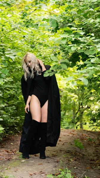 Sexy blonde Frau im schwarzen Mantel Natur — Stockfoto