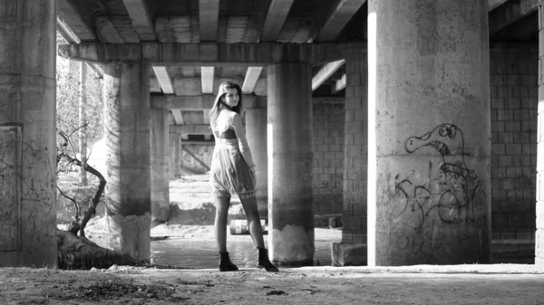 Νεαρή Κοπέλα Μαύρο Φόρεμα Που Ποζάρει Κάτω Από Γέφυρα — Φωτογραφία Αρχείου