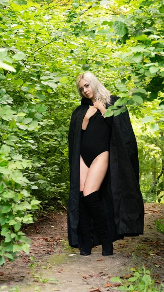 Sexig blond kvinna i svart mantel natur — Stockfoto