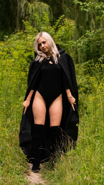 Sexy blonde woman in black cloak nature — Stock Photo, Image