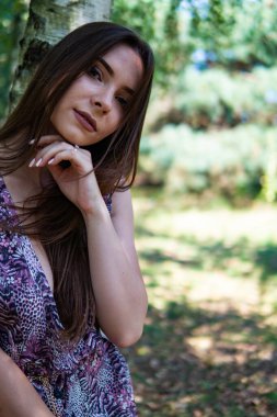 Gölün oradaki tahta iskelede poz veren siyah saçlı kadın. Sırtı Neusiedl Gölü 'nün tahta yaya köprüsüne dönmüş bir kadın. Arka plandaki kayıkhanede güneş yansımaları.