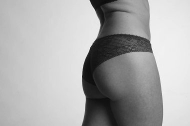 Beyaz arka planda yalnız poz veren dantelli iç çamaşırlı güzel kadın. 