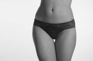 Beyaz arka planda yalnız poz veren dantelli iç çamaşırlı güzel kadın. 