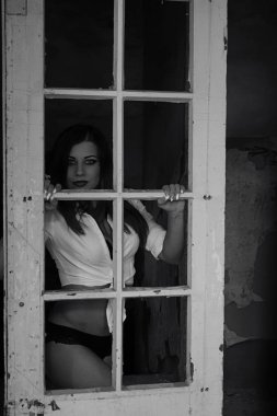 Eski binada iç çamaşırlı seksi esmer kadın poz veriyor.