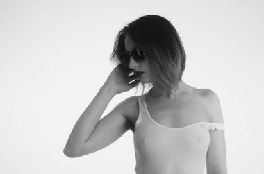 Beyaz tişörtlü güzel kadın beyaz arka planda yalnız poz veriyor. 