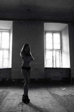 Eski binada iç çamaşırlı seksi esmer kadın poz veriyor.
