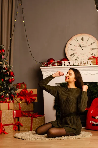 Menina bonita sexy com luxuoso grosso de cabelos castanhos em uma saia preta com uma caixa de presente no fundo da árvore de Natal. Sessão de fotos de Ano Novo — Fotografia de Stock