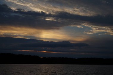 Sabahın erken saatlerinde gölün üzerinde sonsuz karanlık gökyüzü manzarası.   